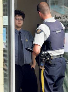 Regan Swallow talks with police inside MP Cathy McLeod's office around 10 a.m. Monday. Swallow and four others were protesting for the release of Marc Emery who has been extradited to the U.S. for selling cannabis seeds across the boarder. (Photo by Shane Kurki)
